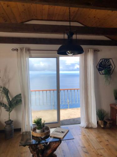 a living room with a view of the ocean at Vigia dos Machados in Lajes do Pico