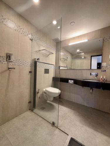 a bathroom with a toilet and a glass shower stall at ViaVia Boutique Hotel - Kathmandu in Kathmandu