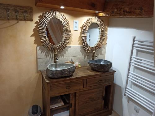 une salle de bain avec deux lavabos et des miroirs au mur dans l'établissement Maison de 225m2 avec piscine, spa et billard, à Floirac