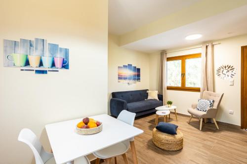 a living room with a white table and a blue couch at Nelly's Place Garden house 2 in Zakharo