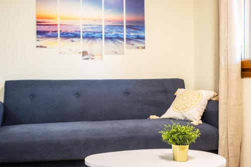 a living room with a blue couch and a table at Nelly's Place Garden house 2 in Zakharo