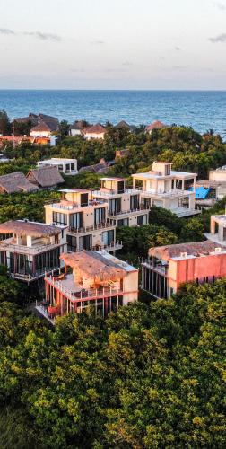 an aerial view of a cluster of buildings near the ocean at Caimán Hábitat Boutique Hotel & Wellness, Tulum Beach in Tulum