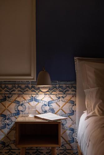 a bedroom with a table with a bed and a lamp at Boutique Chiado Suites in Lisbon