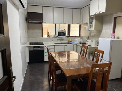 a kitchen with a wooden table and a kitchen with white cabinets at Marina Bay Atami in Atami