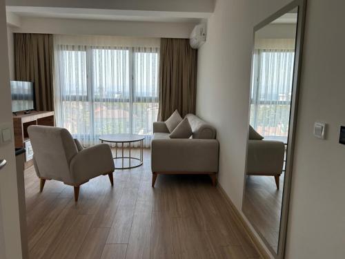 a living room with a couch and a chair and a mirror at Petra Port Hotel in Tuzla
