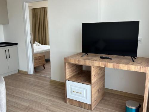 a living room with a flat screen tv on a wooden stand at Petra Port Hotel in Tuzla