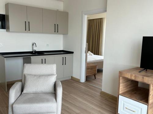 a kitchen and living room with a chair and a television at Petra Port Hotel in Tuzla
