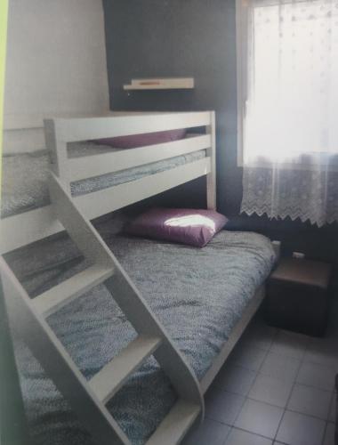une chambre avec deux lits superposés et une fenêtre dans l'établissement Appartement au calme T2 refait à neuf, 2 vélos, avec 2 piscines, 400 m de la mer, au Grau-du-Roi