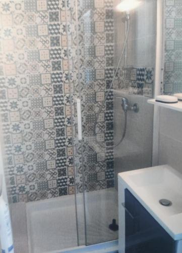 La salle de bains est pourvue d'une douche, d'une baignoire et d'un lavabo. dans l'établissement Appartement au calme T2 refait à neuf, 2 vélos, avec 2 piscines, 400 m de la mer, au Grau-du-Roi