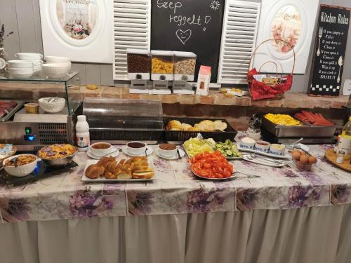 un tavolo con un buffet di cibo sopra di Men's World a Gyula