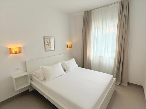 a white bed in a room with a window at Olive Garden in Promajna
