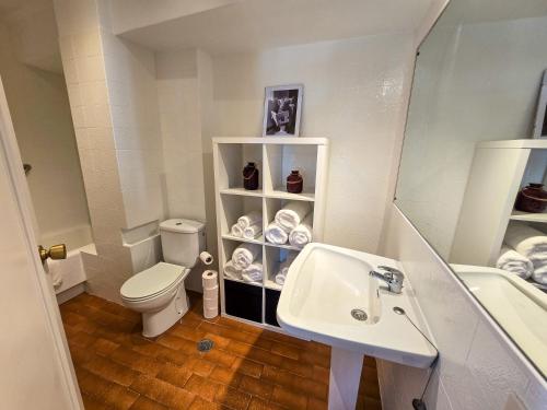 Un baño pequeño con inodoro y lavabo. en Acogedor Apartamento, en Vilagarcía de Arousa
