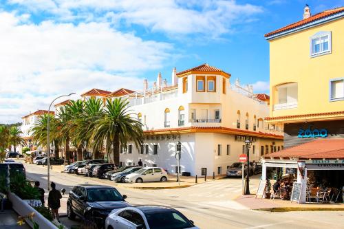 a street with cars parked in front of a building at Hotel Pozo del Duque II in Zahara de los Atunes