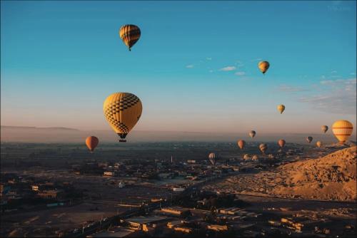 a group of hot air balloons flying over a city at Family Holidays in Luxor