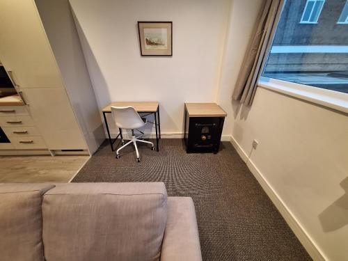 a living room with a couch and a table and a desk at Centre of the town in Whitchurch