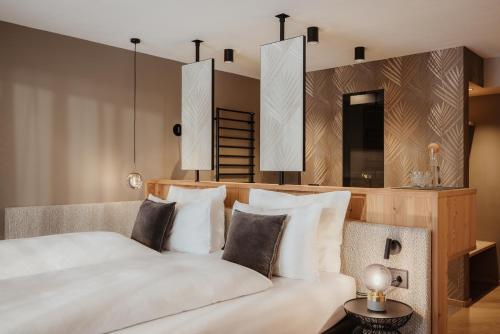 a bedroom with a large white bed with pillows at Hotel Jägerhof in Colfosco