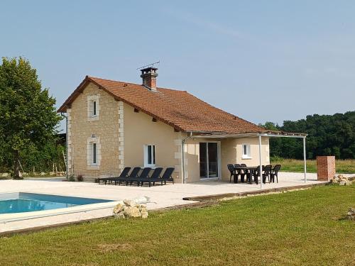 une maison avec une terrasse et une piscine dans l'établissement Maison typique et roulotte vue sur le château d'Hautefort, à Hautefort