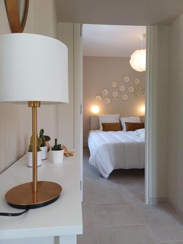 une chambre avec un lit et une table avec une lampe dans l'établissement Maison typique et roulotte vue sur le château d'Hautefort, à Hautefort