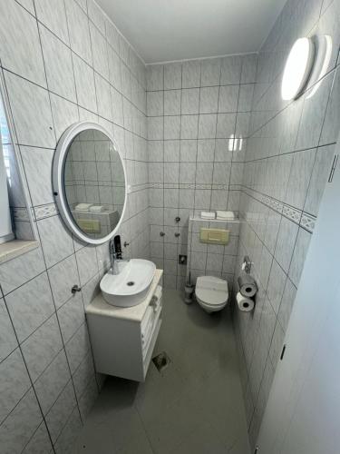 a bathroom with a sink and a mirror and a toilet at Villa Rozika in Baška Voda