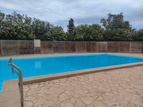 une grande piscine bleue avec une clôture dans l'établissement loue Maison plein pied barcares 28 m2, au Barcarès