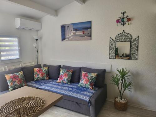 un salon avec un canapé bleu et une table dans l'établissement loue Maison plein pied barcares 28 m2, au Barcarès