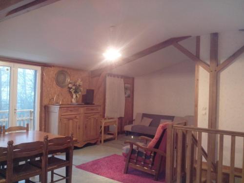un salon avec une table et un canapé dans l'établissement Chalet 3 chambres point de vue depuis la grande terrasse, à Sainte-Colombe