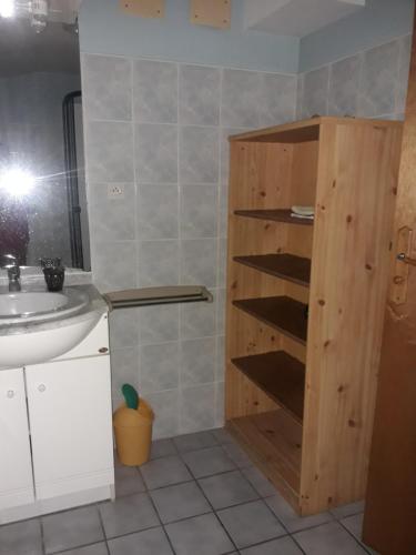 La salle de bains est pourvue d'un lavabo et d'une étagère en bois. dans l'établissement Chalet 3 chambres point de vue depuis la grande terrasse, à Sainte-Colombe