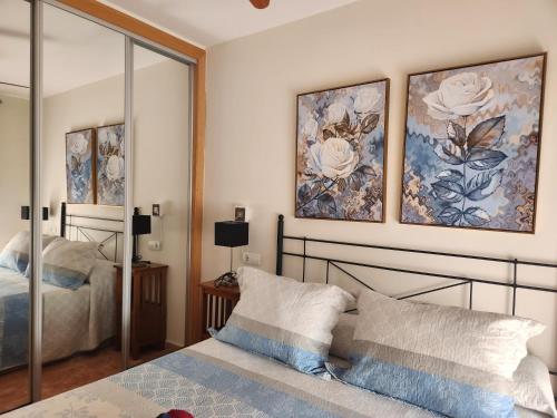 a bedroom with a bed and two paintings on the wall at Ático precioso muy luminoso con piscina privada! in Vera