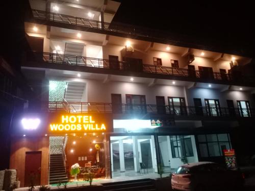 a hotel woods villa at night with a sign in front at Hotel Woods Villa in Chamba