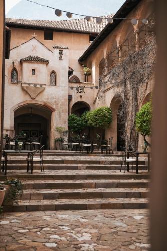 a building with stairs leading up to a building with tables and chairs at Schloss Freudenstein in Appiano sulla Strada del Vino