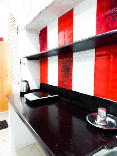 a kitchen with red and white striped wall at White Swan 1BHK Apartement Mysore in Mysore