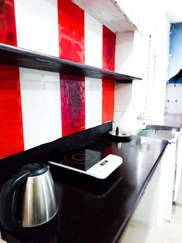 a black counter with a tea kettle on top of it at White Swan 1BHK Apartement Mysore in Mysore