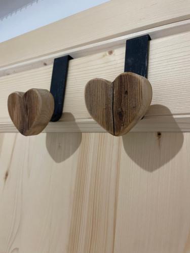 a pair of wooden hearts on a door shelf at Nido Ampezzano in Borca di Cadore