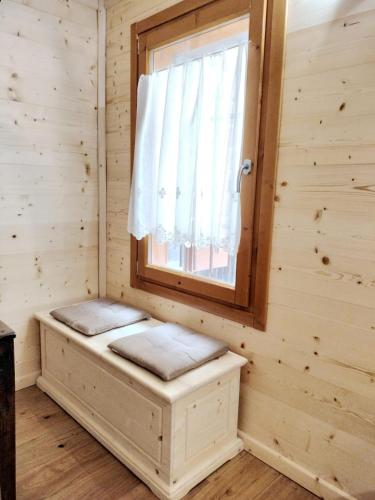 a bench in a room with a window at Nido Ampezzano in Borca di Cadore