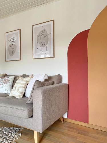 a living room with a couch and two paintings on the wall at Appartement thématique Art Moderne in Travers