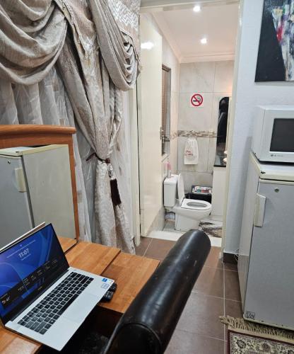 a laptop computer sitting on a table in a bathroom at The Royal Princess B&B on Malibongwe Drive in Johannesburg