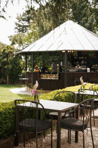 a table and chairs with an umbrella in a garden at Schloss Freudenstein in Appiano sulla Strada del Vino