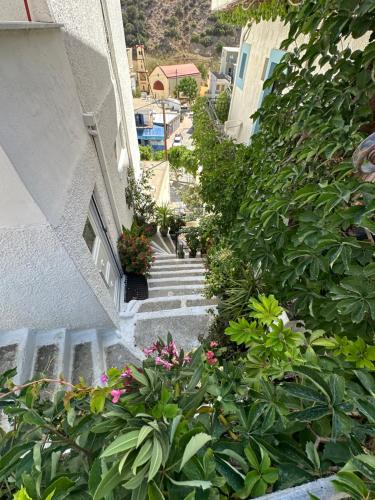 a stairway leading up to a building with flowers and plants at Argiro's apartment at Agia Galini in Agia Galini