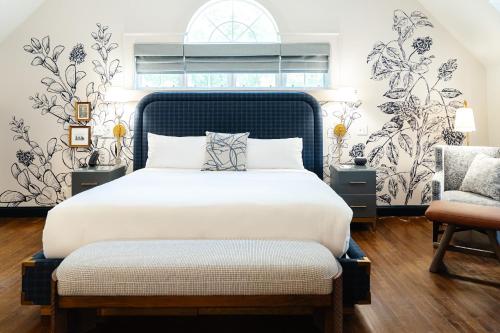 a bedroom with a large bed and a chair at The Sagaponack in Sagaponack