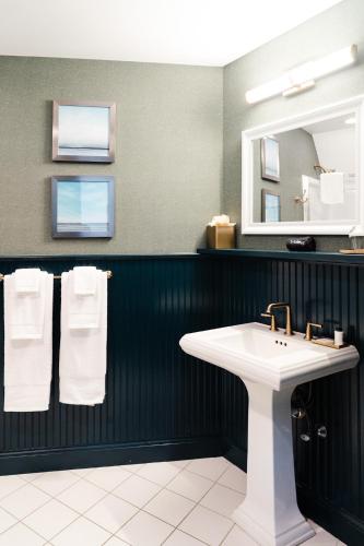 a bathroom with a sink and a mirror and towels at The Sagaponack in Sagaponack