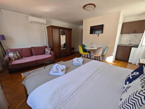 a bedroom with a large bed and a couch at Beatrix Suites in Budva