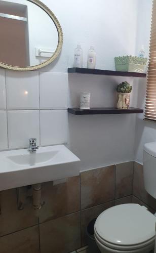 a bathroom with a toilet and a sink and a mirror at 19 on Robyn in Durbanville