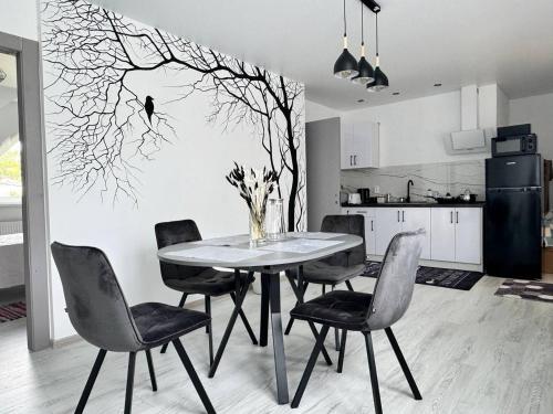 a dining room table with chairs and a tree mural at Koteg LEMBERG in Slavske