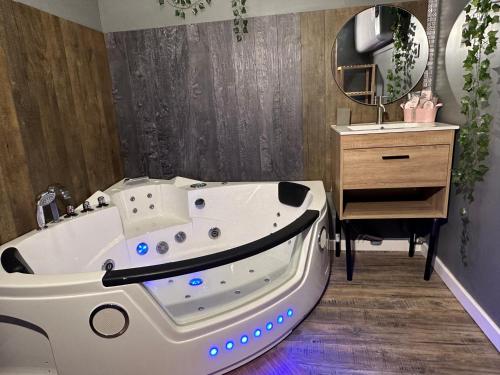 une salle de bain avec une baignoire, un lavabo et un miroir dans l'établissement Au cœur de Perpignan, à Perpignan