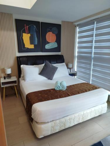 a bedroom with a large bed with two blue bows on it at Uptown Parksuites Tower 1 BGC in Manila