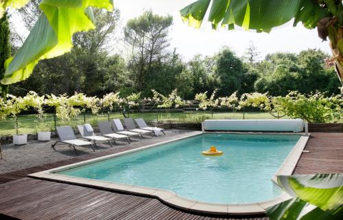 - une piscine avec des chaises et un bateau à jouets dans une cour dans l'établissement L'Authentique, à Landrais