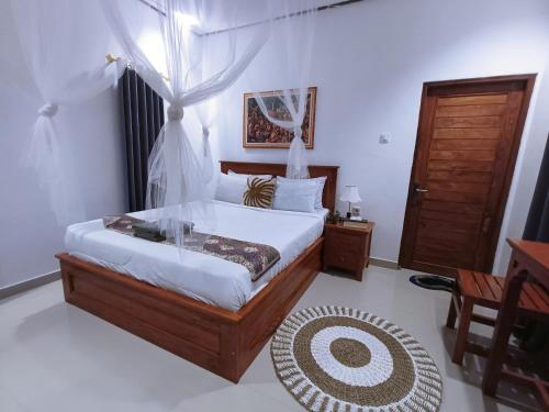 a bedroom with a bed and a table and a door at Bali Cottages Lake View in Kintamani