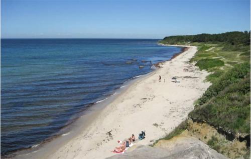 a group of people on a beach near the ocean at 2 Bedroom Gorgeous Home In Hasle in Hasle