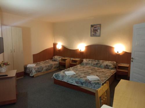 ein Hotelzimmer mit zwei Betten und einem Tisch in der Unterkunft Krasi Hotel in Rawda