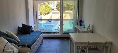 ein Wohnzimmer mit Couch und großem Fenster in der Unterkunft Studio - La Grande Motte in La Grande-Motte